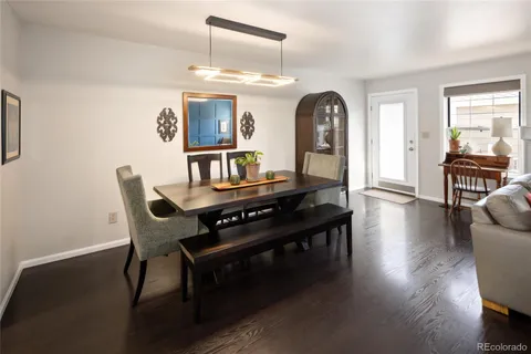 a kitchen with stainless steel appliances granite countertop a stove a sink dishwasher a refrigerator white cabinets and wooden floor