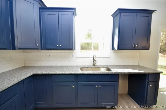 a kitchen with stainless steel appliances granite countertop a refrigerator a stove and a sink with wooden cabinets