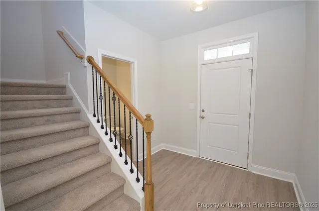 a view of a hallway with wooden floor and entryway