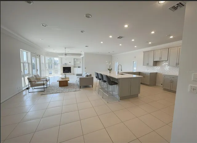 a large kitchen with kitchen island a large counter top stainless steel appliances and cabinets