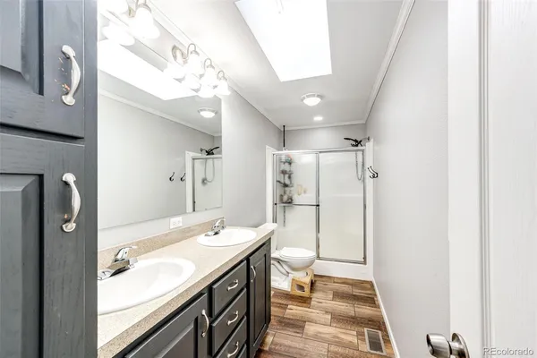 a spacious bathroom with a double vanity sink toilet and shower