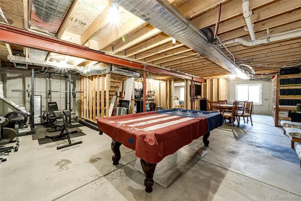 a room with pool table and chairs