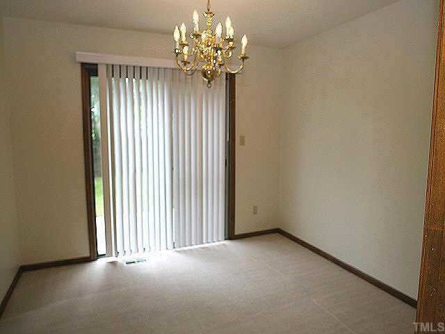 3720 Dusty Lane Raleigh, NC 27604 - Photo 4 of 11 an empty room with a chandelier fan and windows