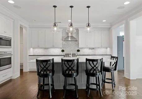 a large kitchen with kitchen island a sink table and chairs