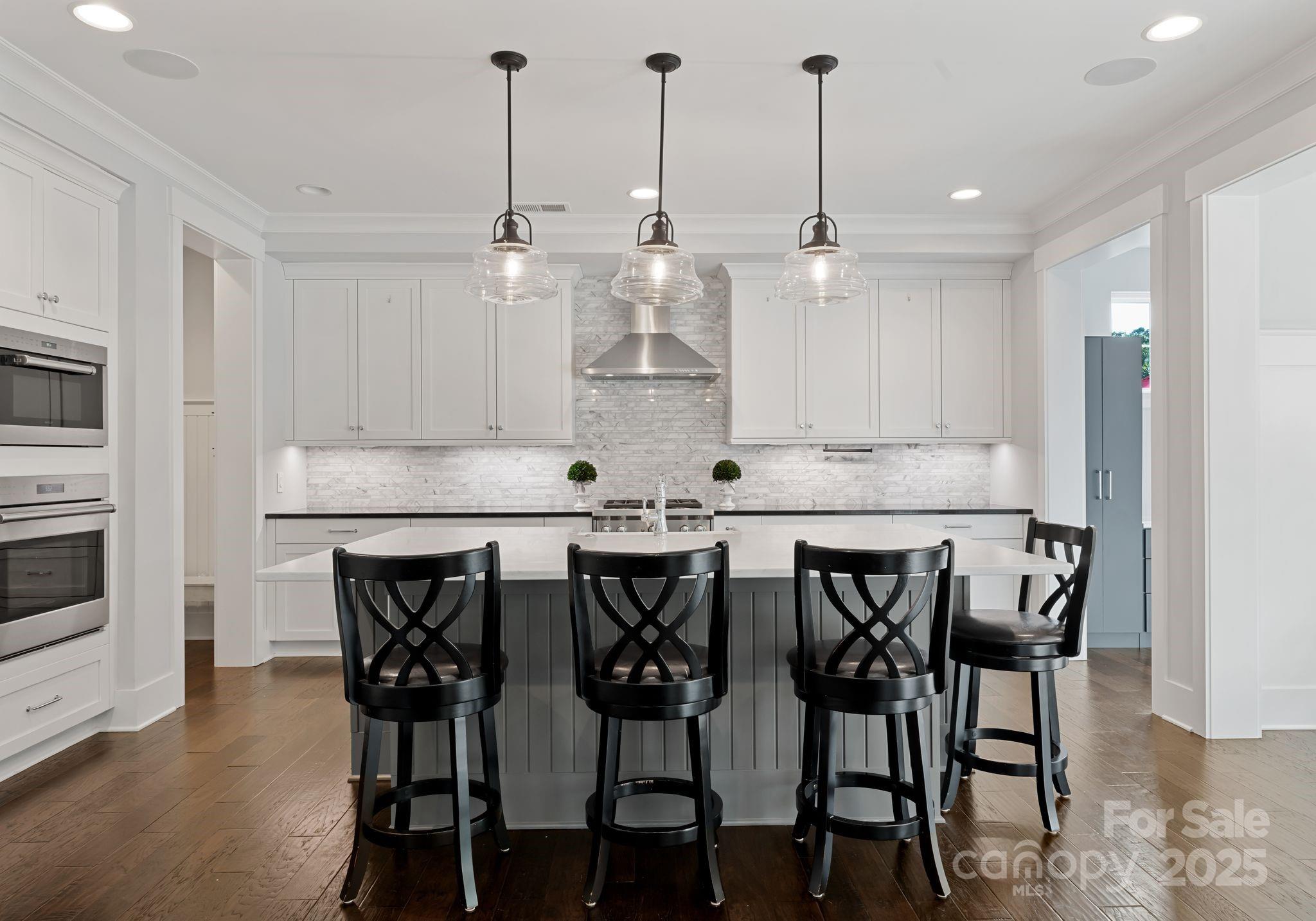 9043 Golden Rock Lane Huntersville, NC 28078 - Photo 22 of 48 a kitchen with stainless steel appliances kitchen island a dining table chairs and sink