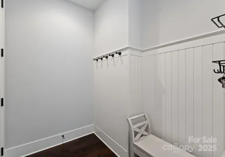 a dining room with wooden floor a chandelier a wooden table and chairs