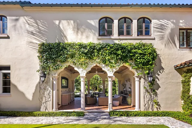 a view of a white building with a swimming pool and porch