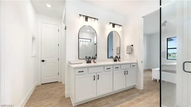 a bathroom with double vanity sink a mirror and a shower