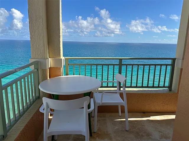 a view of a chairs and table in the balcony