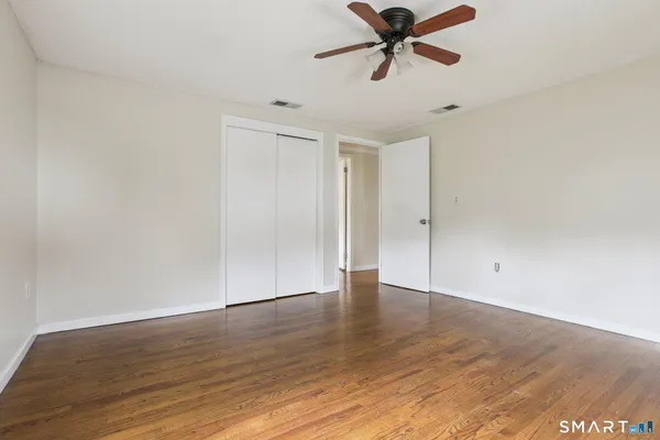 a view of an empty room with wooden floor