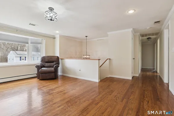 a living room with furniture and a wooden floor