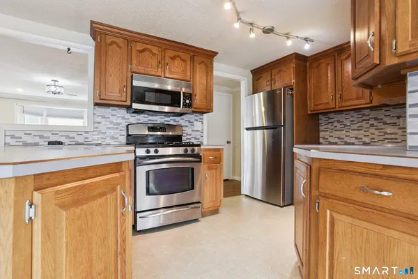a kitchen with stainless steel appliances granite countertop a refrigerator stove and microwave