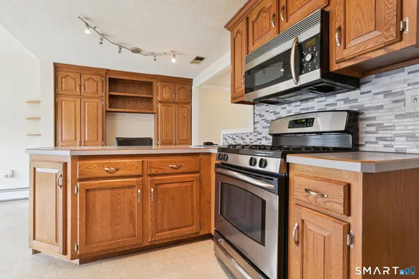 a kitchen with stainless steel appliances granite countertop a stove microwave and cabinets