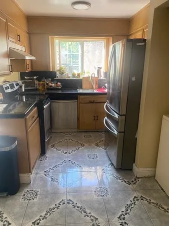 a kitchen with a sink a stove a refrigerator a window