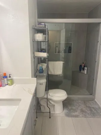 a bathroom with a sink a toilet and shower