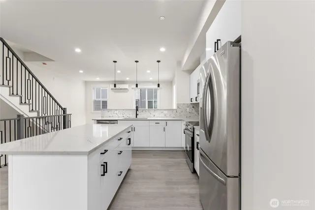 a kitchen with white cabinets and refrigerator