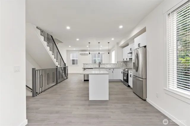 a kitchen with stainless steel appliances kitchen island a stove a refrigerator a sink and a microwave