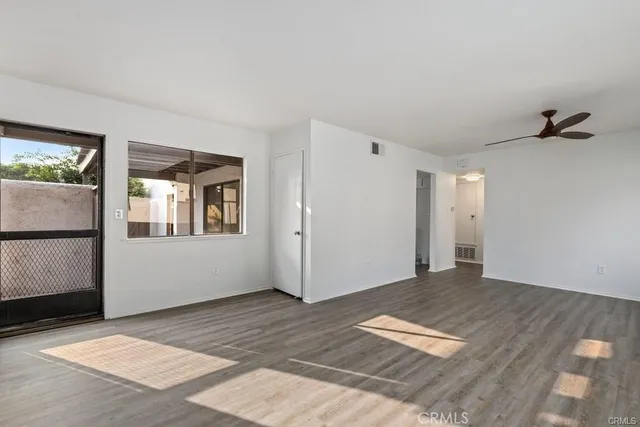 a view of a livingroom with wooden floor and a hallway