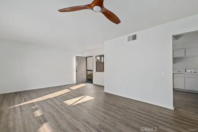 a view of empty room with wooden floor
