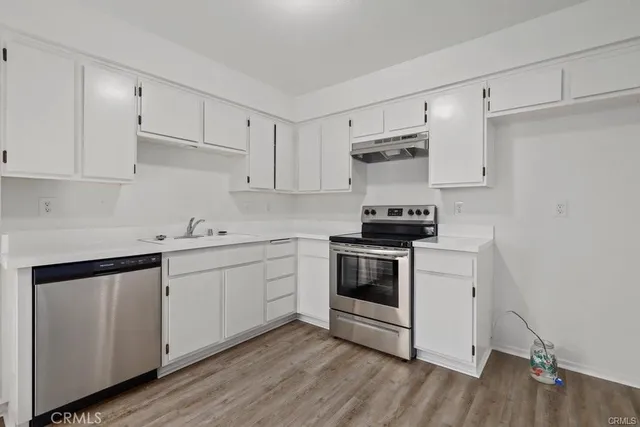 a kitchen with granite countertop white cabinets and white appliances