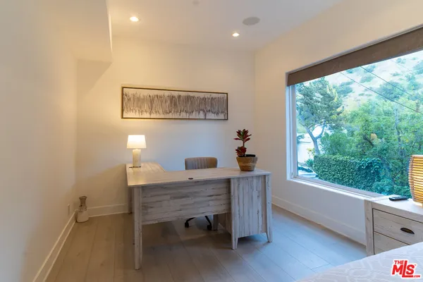 a view of a workspace with furniture and a window