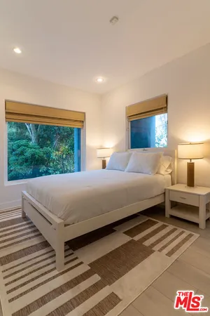 a bedroom with a bed and a large window