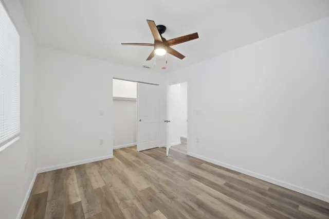a view of empty room with wooden floor