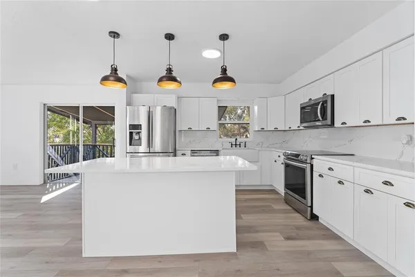 a kitchen with stainless steel appliances white cabinets and a refrigerator