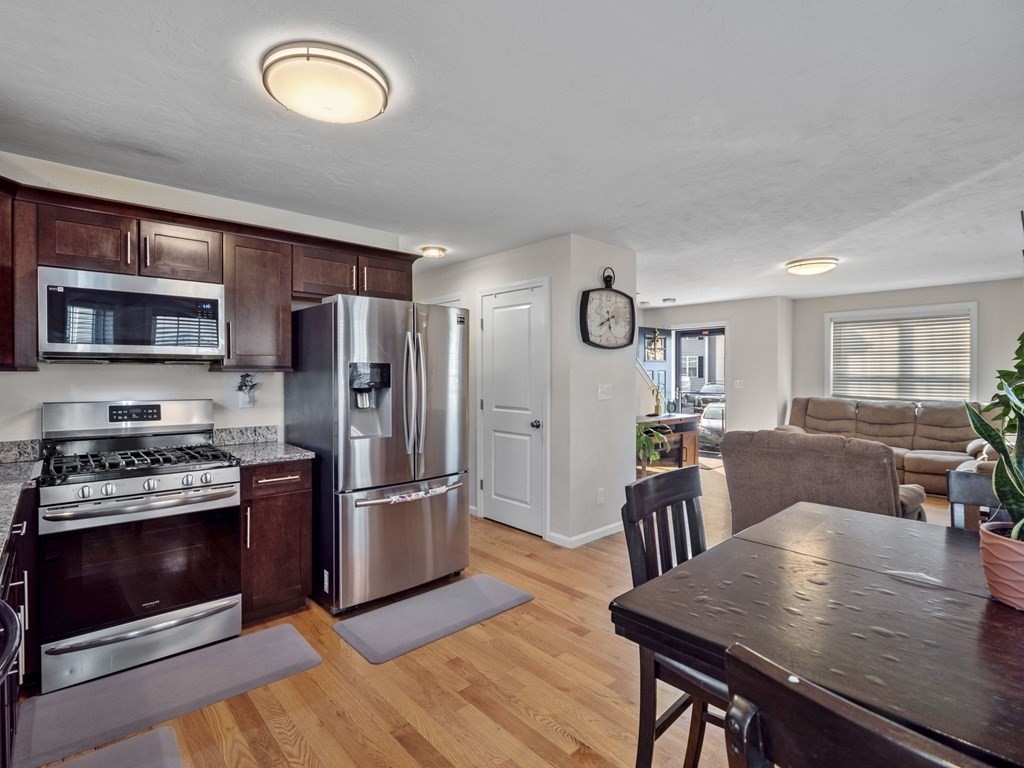 27 Riley Road, Unit 27 Tyngsborough, MA 01879 - Photo 14 of 37 a kitchen with a table chairs refrigerator and microwave