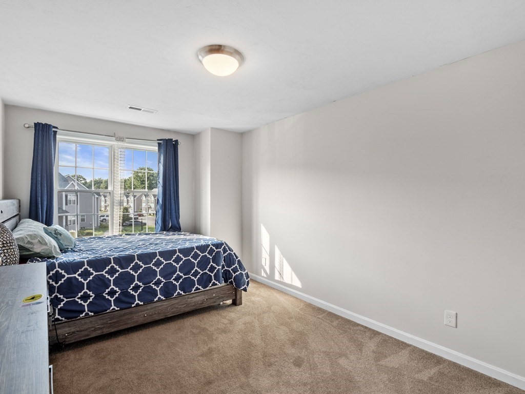 27 Riley Road, Unit 27 Tyngsborough, MA 01879 - Photo 17 of 37 a large bed sitting in a bedroom next to a window