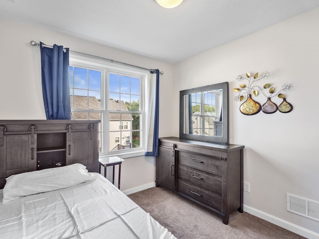 27 Riley Road, Unit 27 Tyngsborough, MA 01879 - Photo 20 of 37 a bedroom with a bed and a dresser