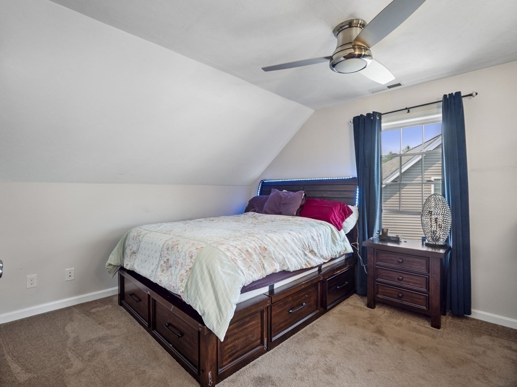 27 Riley Road, Unit 27 Tyngsborough, MA 01879 - Photo 25 of 37 a bed sitting in a room next to a window