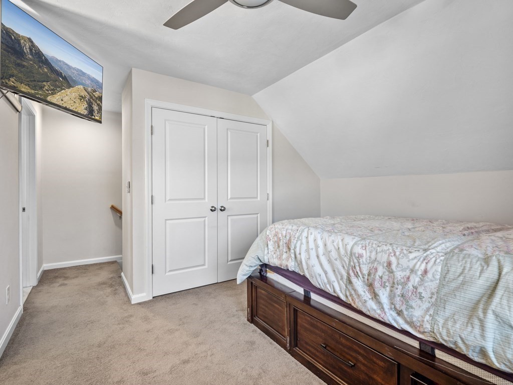 27 Riley Road, Unit 27 Tyngsborough, MA 01879 - Photo 27 of 37 a bed sitting in a bedroom next to a cabinet