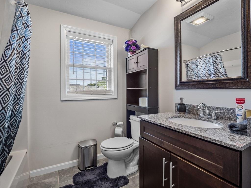 27 Riley Road, Unit 27 Tyngsborough, MA 01879 - Photo 28 of 37 a bathroom with a granite countertop toilet sink and mirror