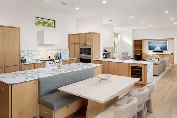 a large kitchen with kitchen island a sink table and chairs