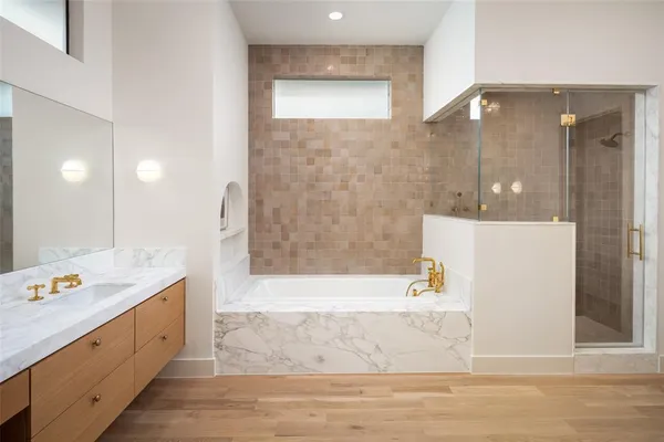 a bathroom with a tub sink and mirror