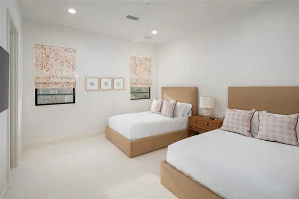 a bedroom with two beds and painting on the wall