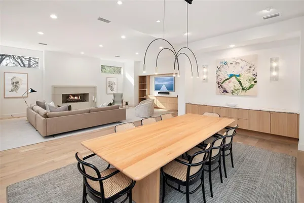 a view of a dining room with furniture a rug and wooden floor