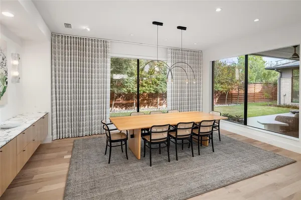 a dining room with furniture a chandelier and wooden floor
