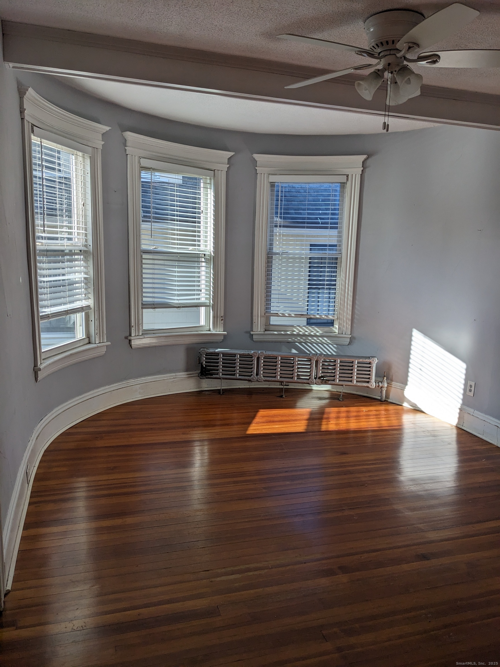 2870 Fairfield Avenue, Unit 2 Bridgeport, CT 06605 - Photo 4 of 15 a view of empty room with wooden floor and fan