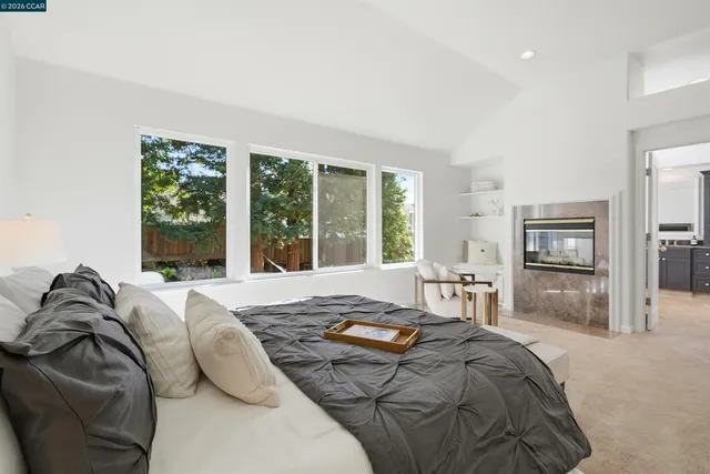 a bedroom with a bed a large window and walk in closet