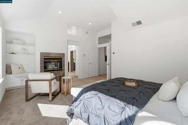 a bedroom with a bed a couch and a flat screen tv