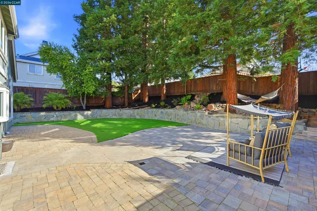 a view of backyard with seating area and trees