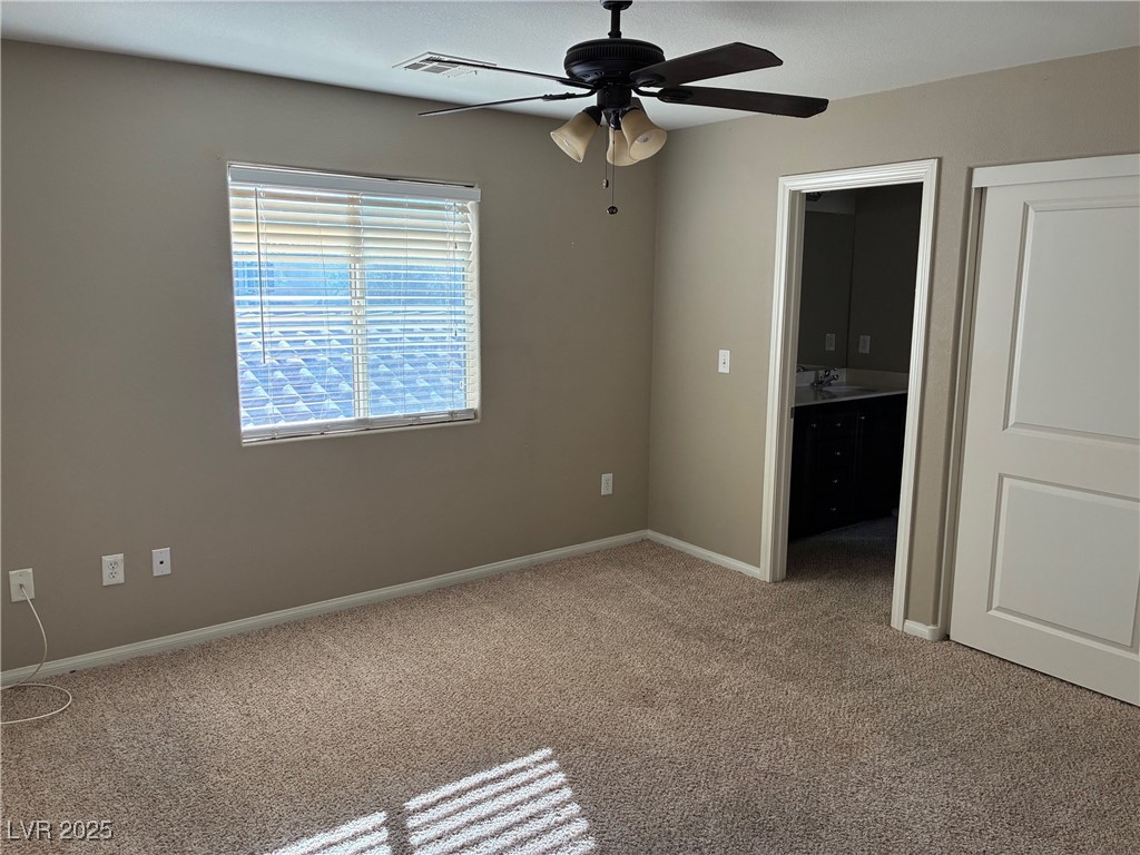 58 Lions Den Avenue North Las Vegas, NV 89031 - Photo 9 of 10 Unfurnished bedroom with light colored carpet and ceiling fan