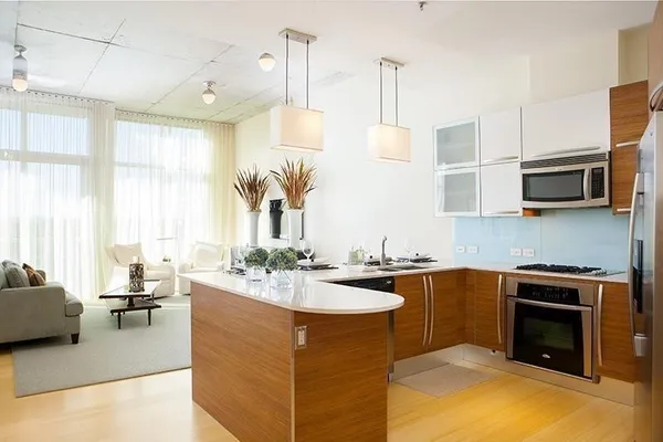 a kitchen with stainless steel appliances granite countertop a sink a stove and a wooden floors