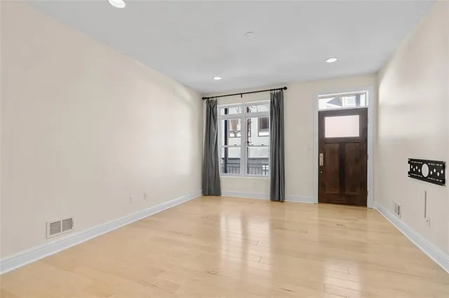 a view of empty room with wooden floor