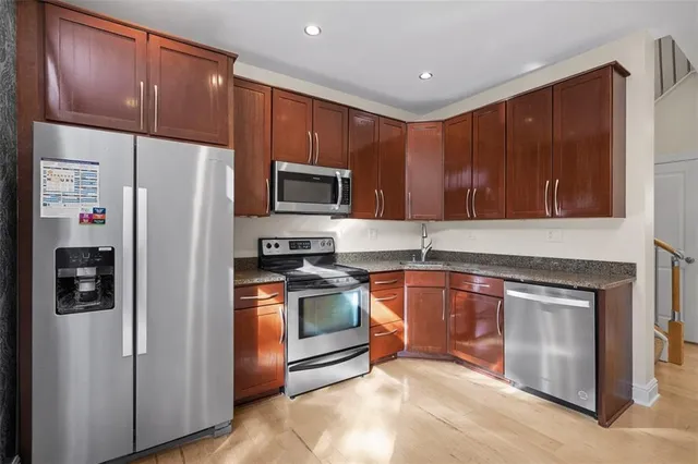 a kitchen with stainless steel appliances granite countertop a refrigerator stove and sink