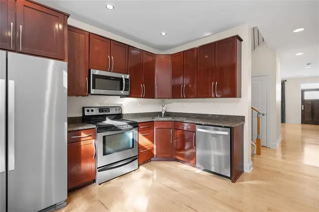 a kitchen with stainless steel appliances granite countertop a stove a refrigerator and a microwave