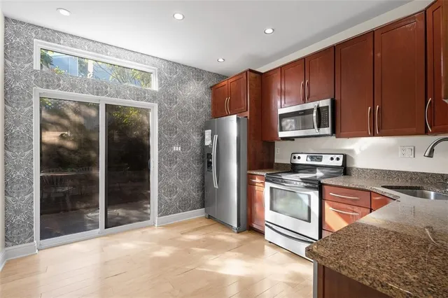 a kitchen with stainless steel appliances granite countertop a refrigerator stove and sink