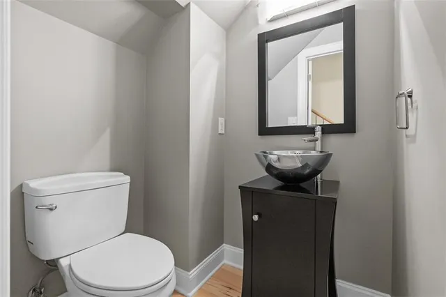 a bathroom with a toilet a sink and mirror